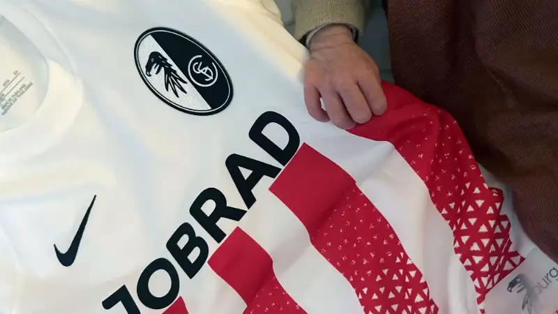 Frisch beschenkt: Baby zupft am SC-Trikot Frisch beschenkt: Baby zupft am SC-Trikot