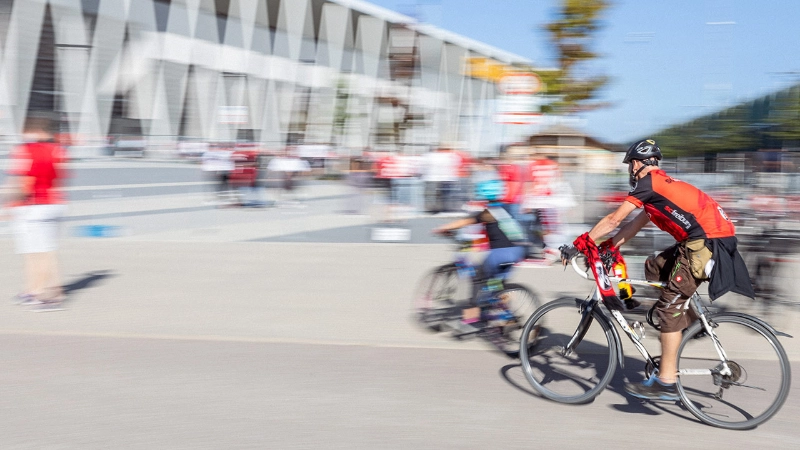 SC Fans in Trikots und Schal fahren mit dem Rad zum Europa-Park Stadion, mit Bewegungsunschärfe SC Fans in Trikots und Schal fahren mit dem Rad zum Europa-Park Stadion, mit Bewegungsunschärfe